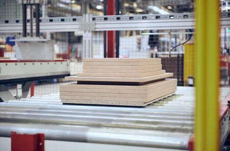 Industrial automated robot wood cutting machinery cutting wooden chip board flat pack furniture in a...