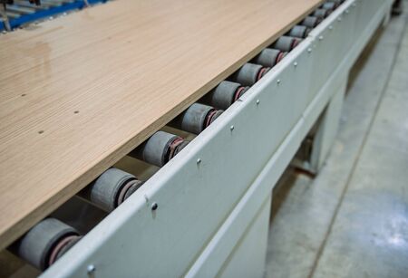 plywood on an industrial roller conveyor belt in a fully automated factory. roller conveyor to easily move heavy industrial goods around without the need for humans.future of industrial manufacture.の写真素材
