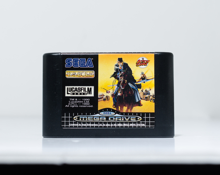 london, england, 05/05/2019 A indiana jones sega mega drive video game cartridge isolated on a white studio background. Retro and vintage console game playing from the 1990s.のeditorial素材