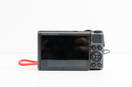 london, england, 05/08/2019 A digital point and shoot canon power shot camera isolated on a white background. Digital camera LCD glass touch screen and function buttons.のeditorial素材