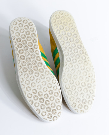 london, england, 05/05/2018  Adidas Gazelle Mustard Gold & Green Stripe Trainers vintage sneaker trainers. yellow suede adidas trainers, stylish retro football street fashion. famous three stripesのeditorial素材