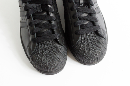 london, england, 05/05/2018 adidas superstar shell toe originals hip hop style vintage sneaker trainers. all black adidas superstar trainers, stylish retro  new york street fashion.のeditorial素材