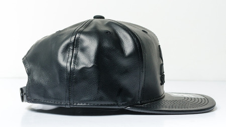 new york, usb, 05/05/2019 A black leather starter baseball cap, starter black label snap back cap, associated with hip hop and gangster fashion.urban street style isolated on a white backdrop.のeditorial素材