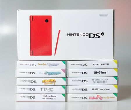 lodnon, england, 05/05/2019 A gloss red nintendo ds hand held vintage console on a white studio background. Retro video gaming handset. nostalgic computer and arcade games.のeditorial素材