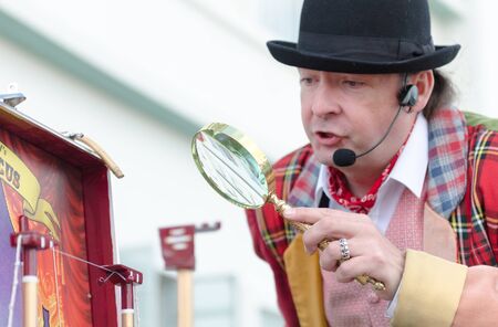 london, england, 15/03/2019 A flea circus street performer with a magnifying glass entertaining...