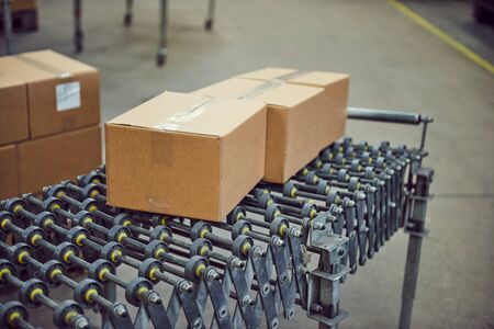 Parcels for delivery on an industrial roller conveyor belt in a fully automated online retailer...