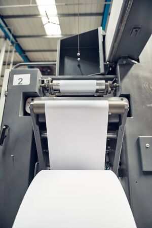 A toilet paper making machine, producing toilet and bathroom paper rolls due to Corona virus panic buying.  Paper and tissue manufacturers factory and engineered machinery.の写真素材