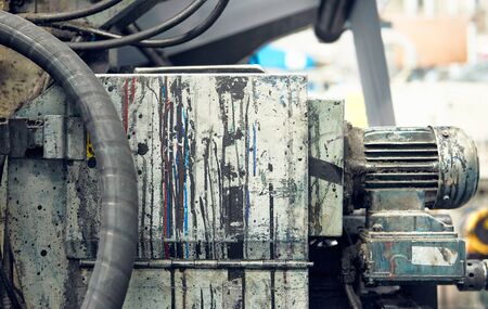 Artistic colourful ink and paint drips on a silver metallic textured background in an industrial...