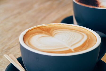 A beautiful creamy brown warm fresh cappuccino coffee cup, full of creamy coffee, served in a wooden...