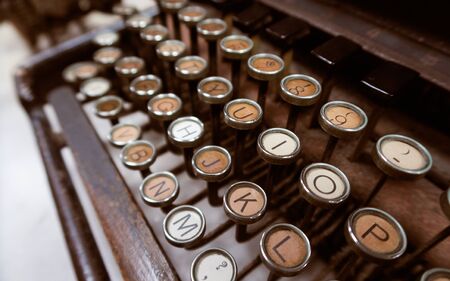 A rusty dirty old decaying vintage antique type writer sat in an office on a table. Scary abandoned horror story typewriter with orange and brown rust. story telling equipment                 の写真素材