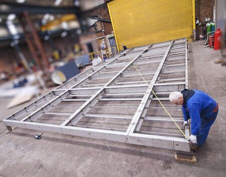 london, england, 05/05/2018 An apprentice engineer using a tape measure to inspect and measure a...