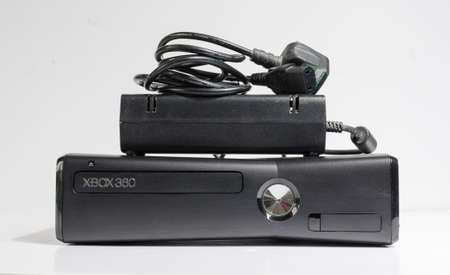 london, england, 05/05/20202 A slim line black Microsoft xbox 360 home arcade console isolated on a...