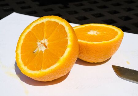 A beautiful vivd colourful juicy sliced orange, showing tasty sweet orange segments, on a white background. Vitamin C and nutritious exotic fruits.の写真素材