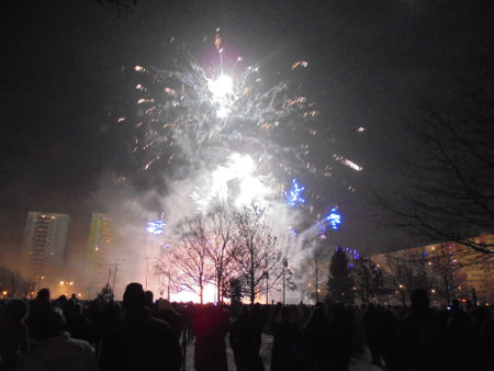 Smoking effect of white fireworks during New Year pyrotechnics show flashing on buildings and people.の写真素材