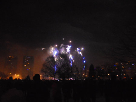 Yellow and blue pyro show producing lots of dust, smoke and noise covering surrounding buildings during New Year midnight.の写真素材