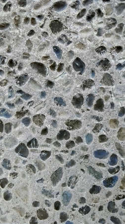 Inverted colors - Background photo with concrete pavement filled with multiple white and gray stones and pebbles.の写真素材