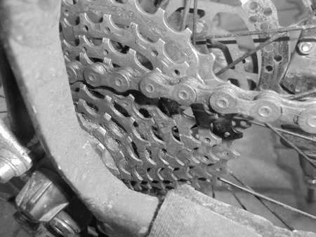 Retro image - Front close-up on mountain bike chain attached to slightly dirty nine speed gear casette.の写真素材