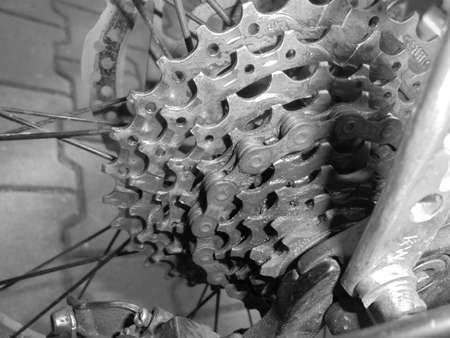 Gray shaded - Detailed view of silver MTB bike gear with nine speeds, slightly dirty, with chain.の写真素材