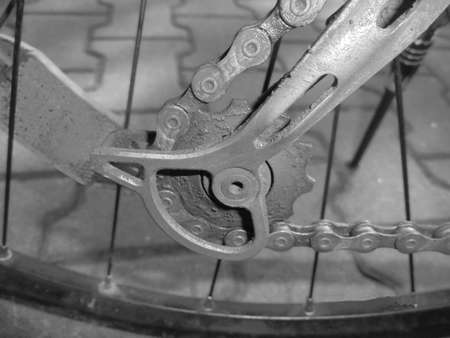Gray shaded - Bottom gear of mountain bike derailleur with chain and orange reflector in the background.の写真素材