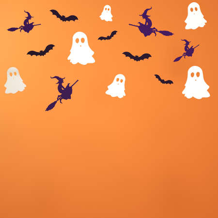 Halloween minimal orange scene with paper ghost, witch, bat. Autumn holiday concept background. Holiday background party decoration. 3d renderingの写真素材
