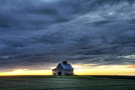 Old barn at sunset with a beautiful contrasting skyの写真素材