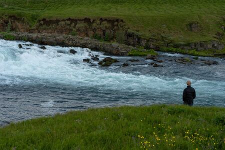 Man watching the river flowの写真素材