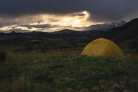Yellow camping tent in an open moss field during sunset. Shot on adventure in Icelandic highlands August 2018の写真素材