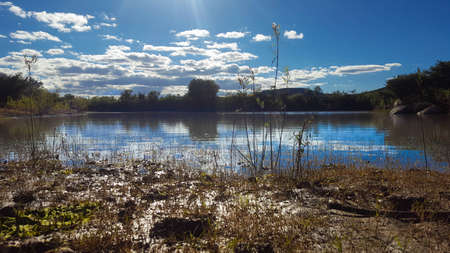 Reflection is the clouds over a lake on a sunny dayの写真素材