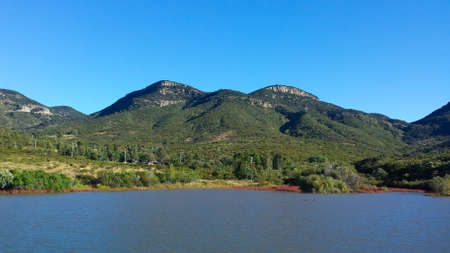 lake on the shore of the mountain on sunny dayの写真素材