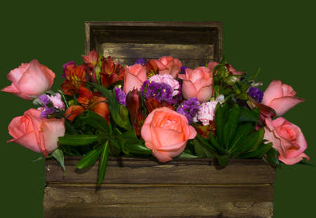 Bouquet of flowers inside a wooden chest whit green backgroundの写真素材
