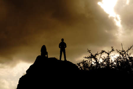 silhouettes on top of a mountain with an epic skyの写真素材