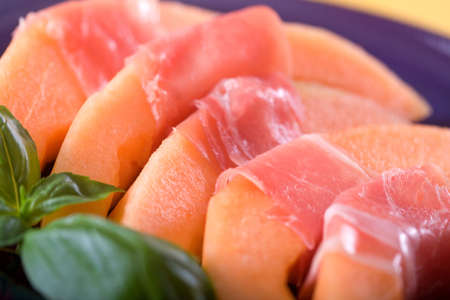 Melon wrapped in prosciutto ham. Italian Appetizer.の写真素材