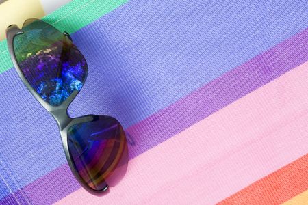 Beach relaxation concept and background featuring a pair of sunglasses on a beach chair.の写真素材