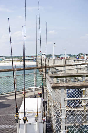 Fishing pole on a jetty and a white boxの写真素材