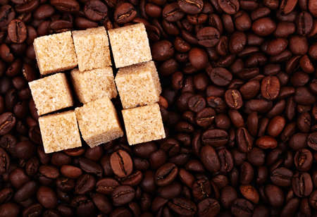 Coffee beans background with nine brown sugar cubes. Natural morning light.の写真素材