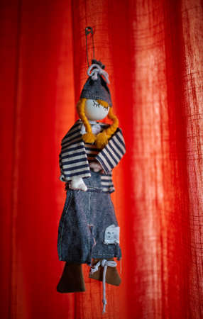 Handmade toy from jeans clothes hanged on curtain