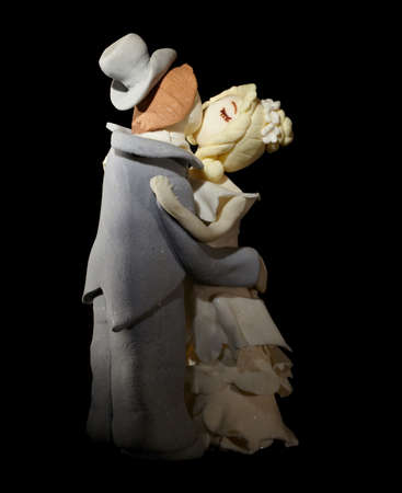 Wedding cake figurines are kissing on black の写真素材