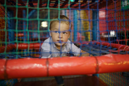 3 year old boy having fun on the playground inside trade centerの写真素材
