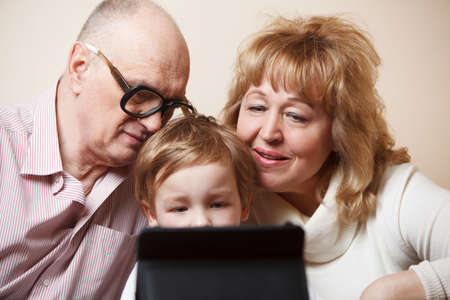Grandparents and their grandson with tablet PC.