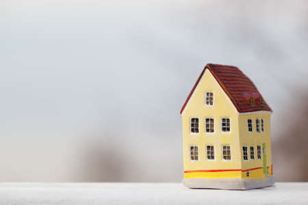 Miniature house figurine on blurry outdoor backgroundの写真素材