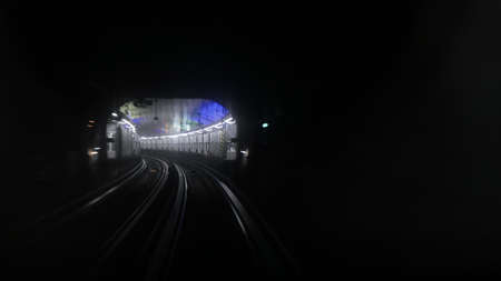 View from driver window of Paris metro subway and station lights around curve in background