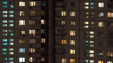 Windows lights in multistorey panel apartment house at night. Old building with cracks on the walls. Moscow, Russiaの写真素材