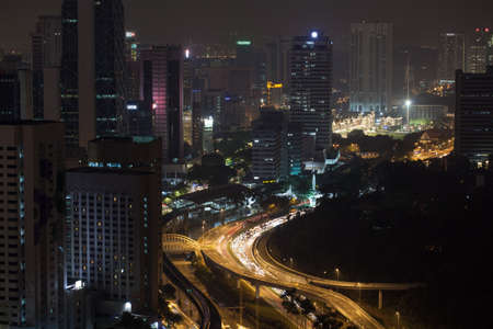Night Kuala Lumpur, Malaysia. City architecture, train and car traffic on illuminated roads