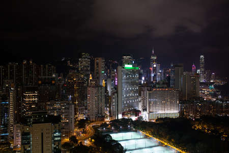 Night view of Hong Kong. Cityscape with illuminated high-rise architecture, highways and football fieldsの写真素材