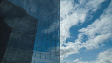 Blue sky, reflected in a sleek wall of a high buildingの写真素材