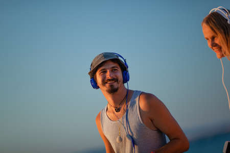 Young man and woman spend time in the open air with headphones on their headsの写真素材