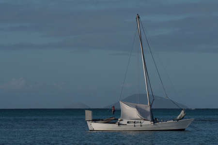 A white boat setting sail in the open sea