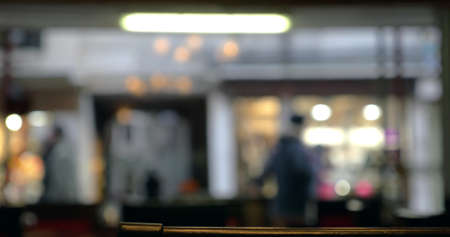Defocused shot of people walking along the street, view through the cafe or restaurant windowの写真素材