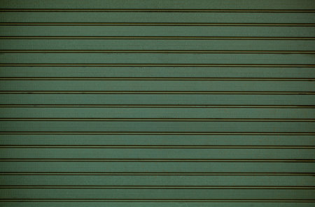 Green wooden wall cladding background texture with repeat pattern of horizontal line in a full frame...