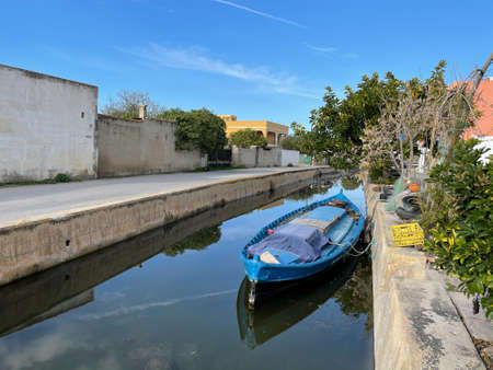 Quiet scenery of El Palmar village with boat in the channel and deserted waterfront, Spainの写真素材